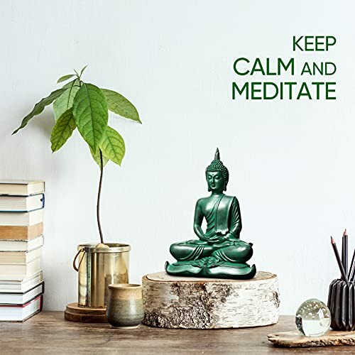 Green Buddha statue on wooden surface with plant and books