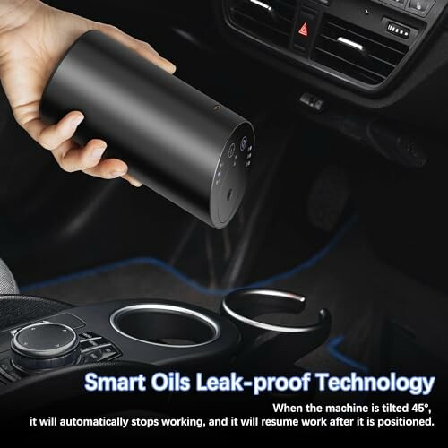 Person holding a smart oil dispenser in a car interior.